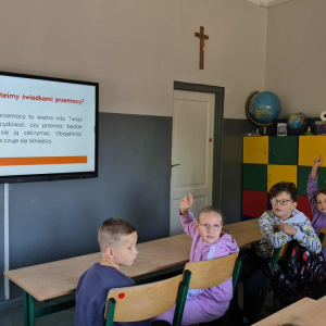 Dzieci oglądają prezentację na temat przemocy 