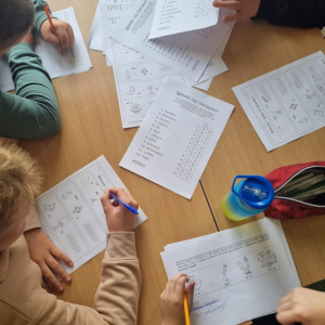 Dzieci rozwiązują karty pracy na temat drzew