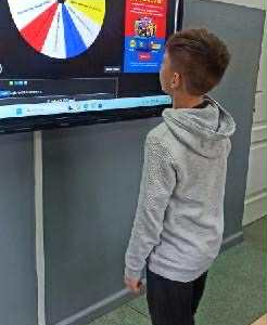 Uczniowie losują sobie zadania na kole życzliwości do wykonania na przerwie