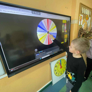 Uczniowie losują sobie zadania na kole życzliwości do wykonania na przerwie