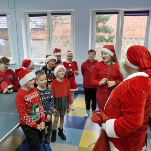 Mikołaj rozdaje dzieciom paczuszki 