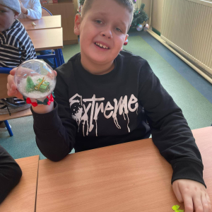 Uczniowie pokazują wykonane przez siebie ozdoby świąteczne 