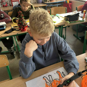 Uczniowie przy stolikach pracują długopisami 3D i zapamiętują zwierzęta z lektury