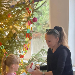 Uczniowie przyjmują gratulacje, dyplom i nagrody od nauczyciela