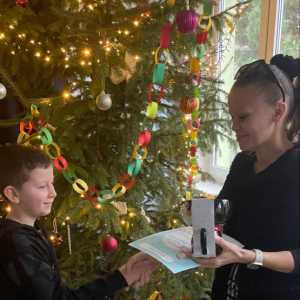 Uczniowie przyjmują gratulacje, dyplom i nagrody od nauczyciela