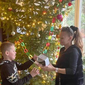 Uczniowie przyjmują gratulacje, dyplom i nagrody od nauczyciela