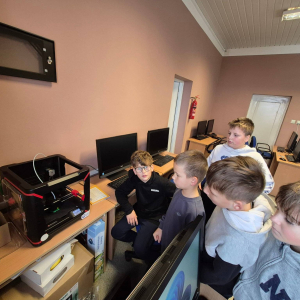 Uczniowie patrzą na pracę drukarki 3D