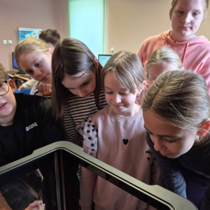 Uczniowie patrzą na pracę drukarki 3D