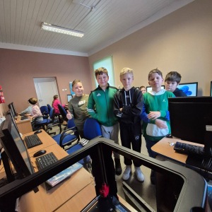 Uczniowie patrzą na pracę drukarki 3D