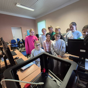 Uczniowie patrzą na pracę drukarki 3D