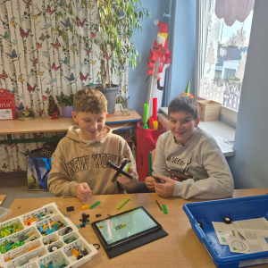 Uczniowie pracują z klockami LEGO 