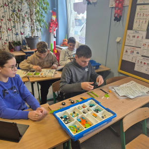 Uczniowie pracują z klockami LEGO 