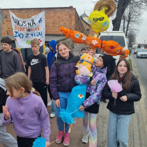 Przemarsz przez wieś z transperentami witajacymi wiosnę