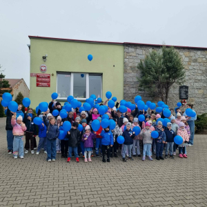 Zjednoczeni z autyzmem- uczniowie w grupowym zdjęciu z niebieskim balonem