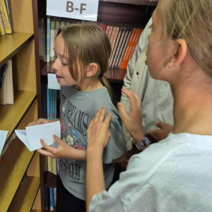 Rozwiązywanie zagadek książkowych przez uczestników warsztatów EskapeRoom