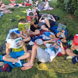 Uczniowie na polanie czytają wybrane przez siebie książki