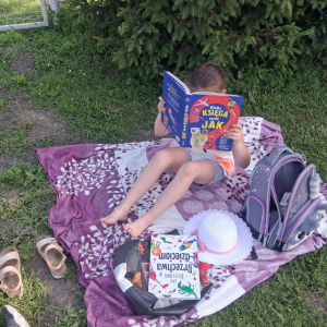 Uczniowie na polanie czytają wybrane przez siebie książki